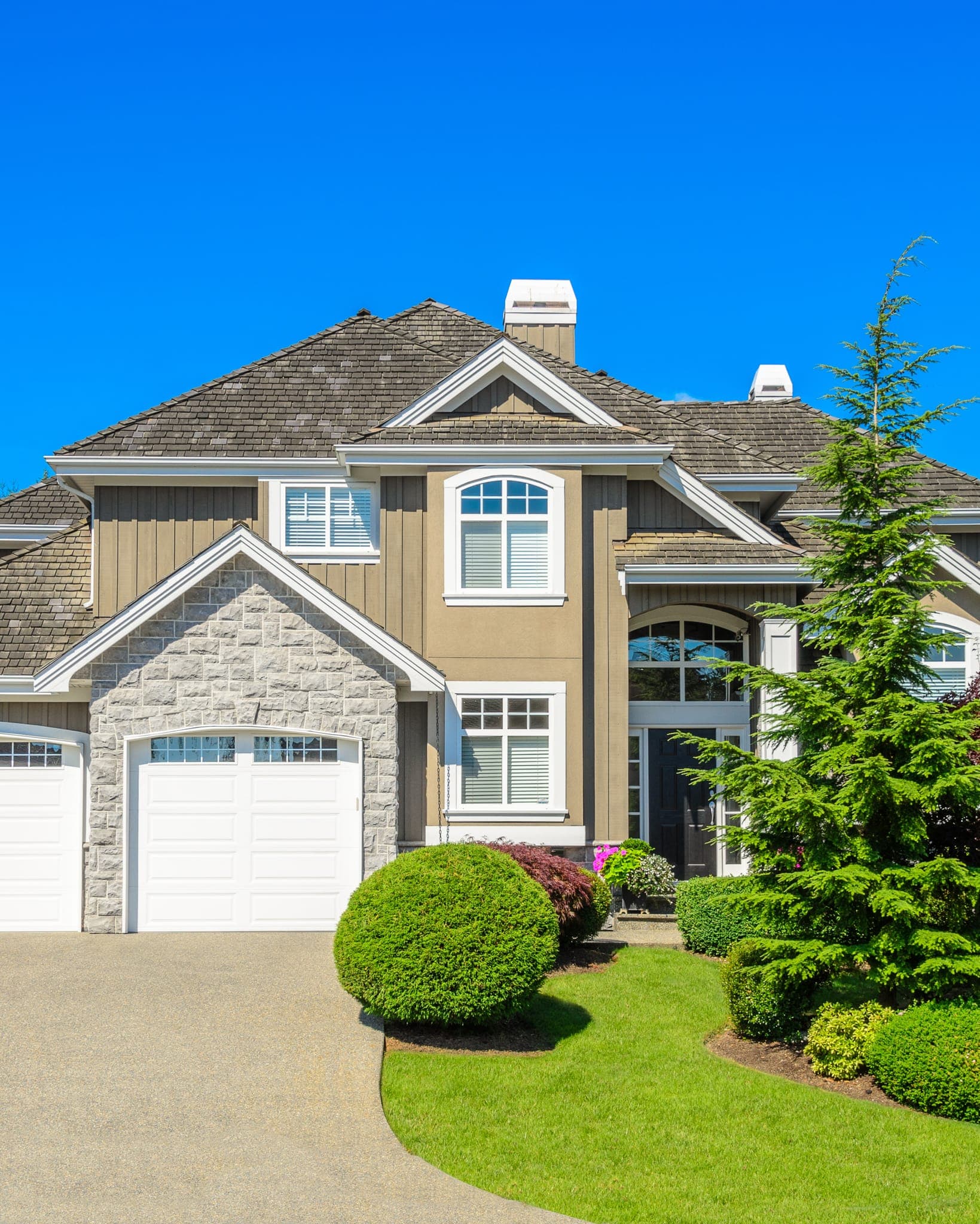 The front elevation of a two-story suburban house with an attached garage and gabled roof
